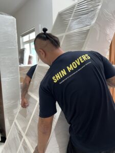 Professional shin movers carrying a big cabinet
